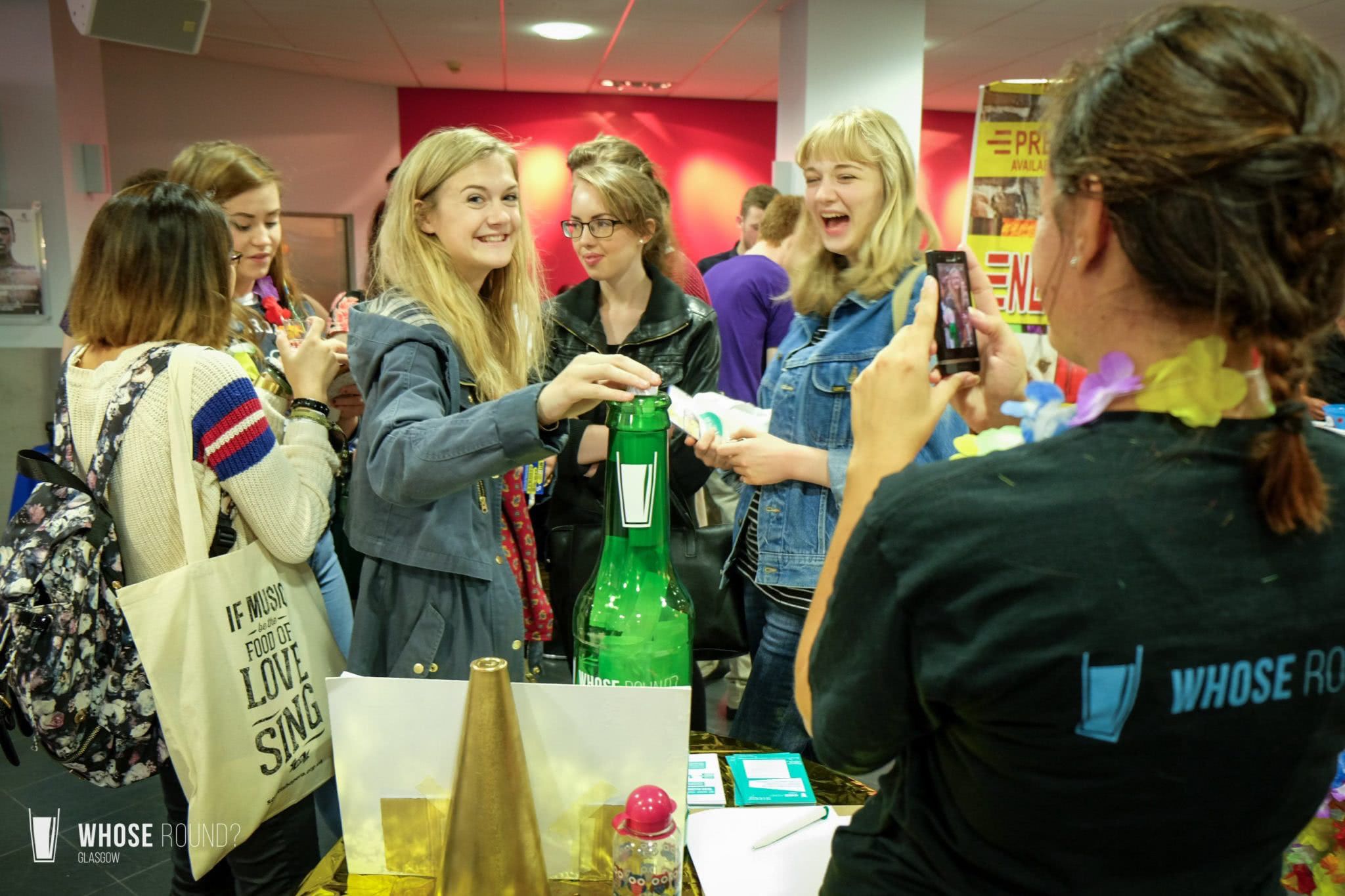 Students putting messages in a plastic bottle at a students fair