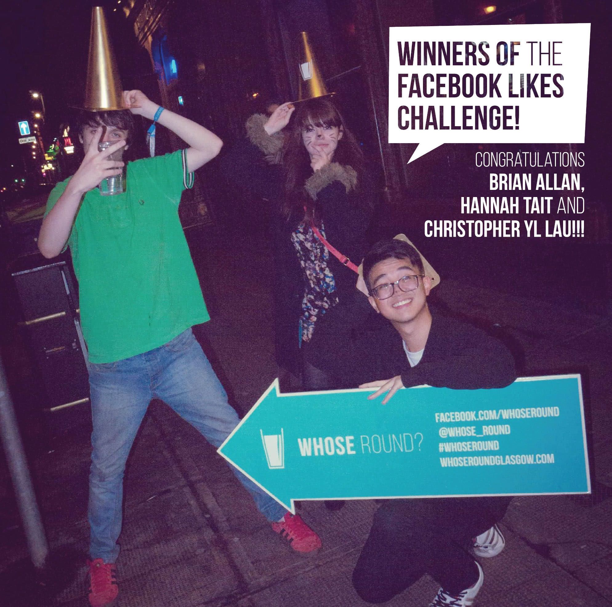 Students holding signs and a big golden cone posing for a photo in the evening